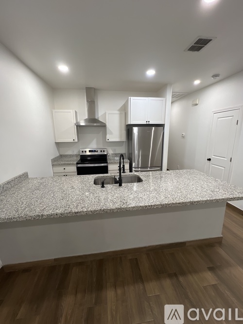 A kitchen with a granite countertop and stainless steel appliances.
