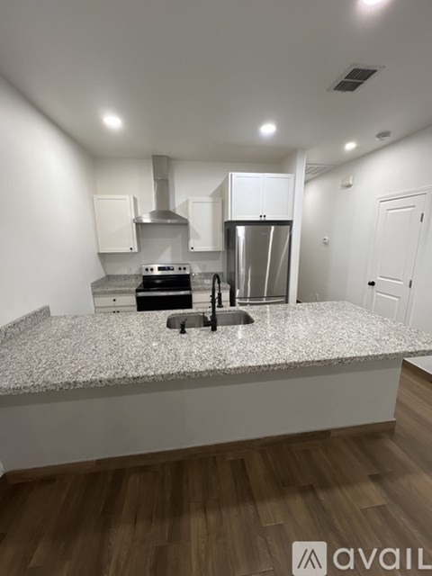 A kitchen with a granite countertop and stainless steel appliances.