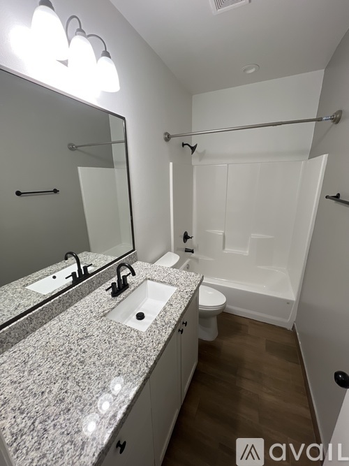 A bathroom with a granite countertop and a walk-in shower.