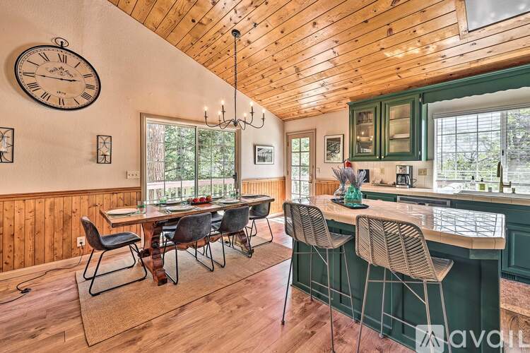 A kitchen with a wooden ceiling and a large table with chairs.