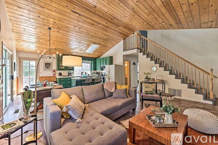A living room with a grey couch and a wooden ceiling.