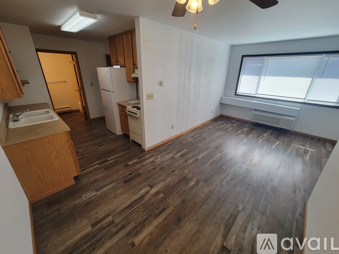 A kitchen with wooden floors and white walls.
