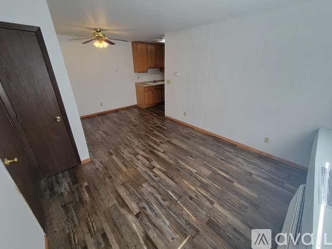 A room with wooden flooring and a ceiling fan.