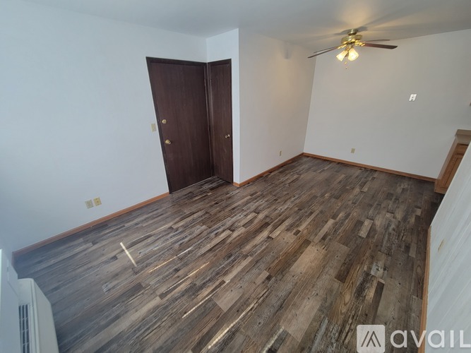 A room with wooden flooring and a ceiling fan.