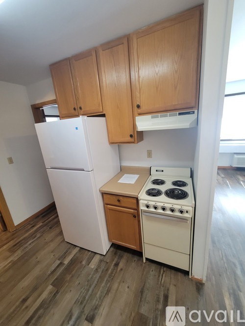 A kitchen with wooden cabinets and a white fridge.