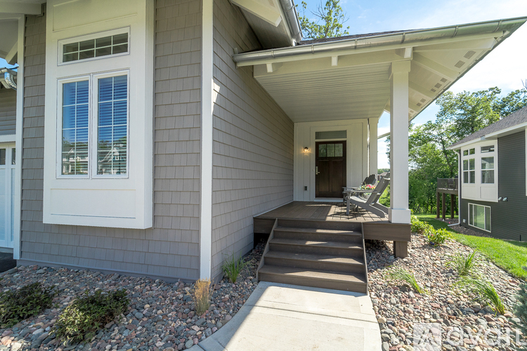 A house with a grey exterior and a white porch.