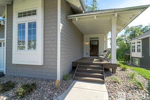 A house with a grey exterior and a white porch.