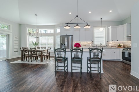 A kitchen with a dining table and chairs in the middle of the room.