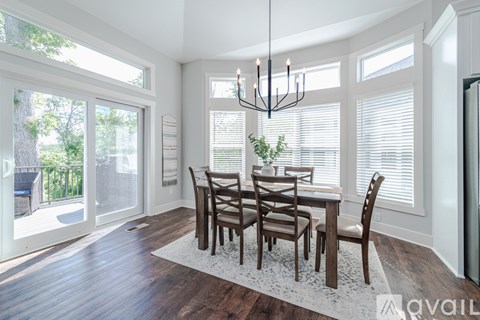 A dining room with a wooden table and chairs.