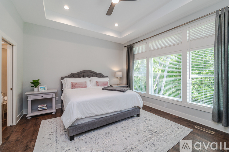 A bedroom with a large bed and a ceiling fan.