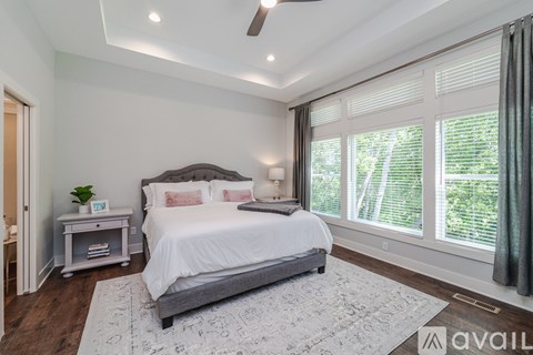 A bedroom with a large bed and a ceiling fan.
