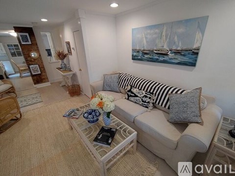 A living room with a sofa, a coffee table, and a painting on the wall.