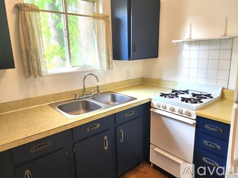 A kitchen with a white stove and blue cabinets.