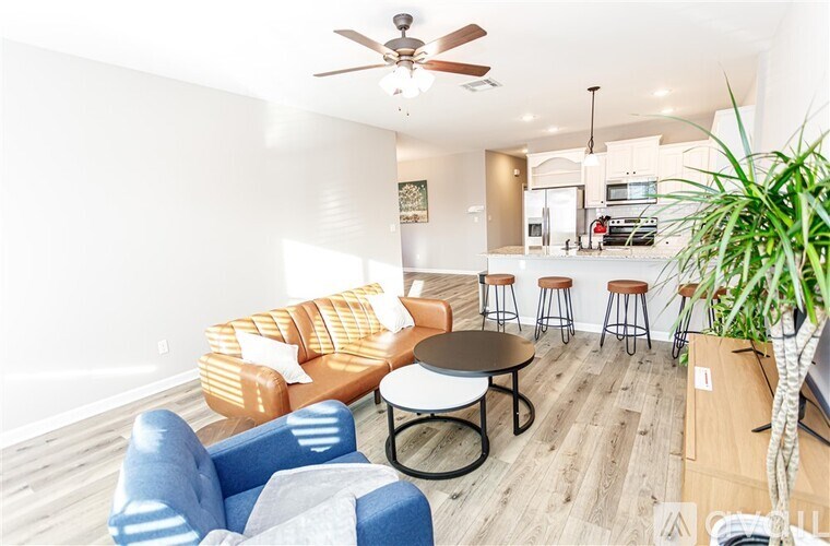 A living room with a blue couch and a ceiling fan.