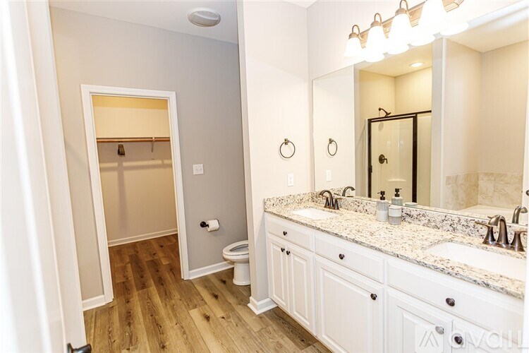 A bathroom with a toilet, sink, and mirror.
