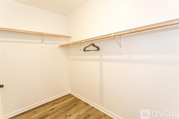 A white closet with a hanger on the rail.