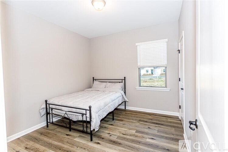 A bedroom with a bed and a window.