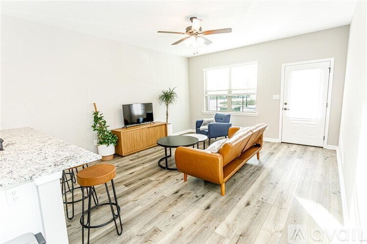 A living room with a sofa, a table, a television, and a bar stool.