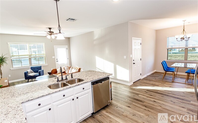 A kitchen with white cabinets and a marble countertop.