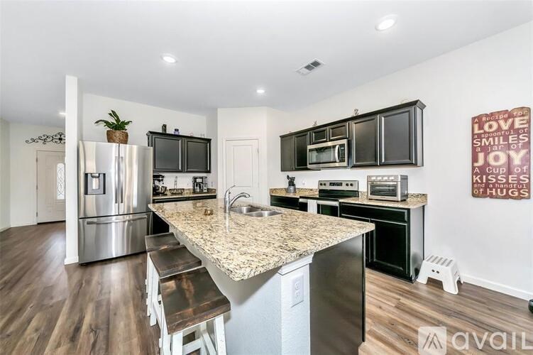 A kitchen with a granite countertop and stainless steel appliances.
