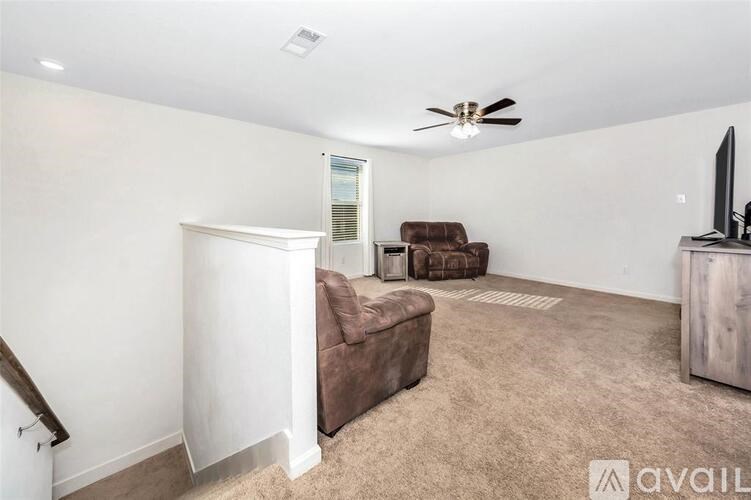 A living room with a brown couch and a white wall.