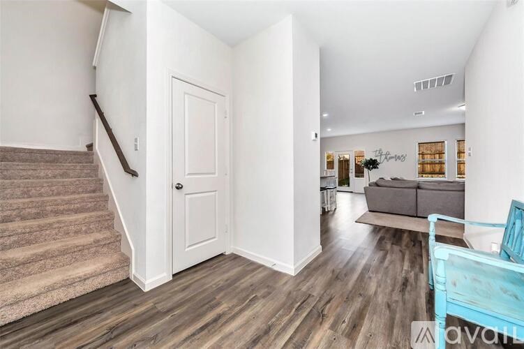 A living room with a couch and a staircase.