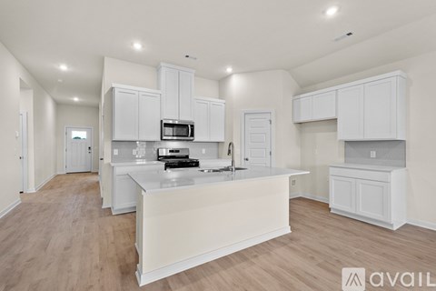 A kitchen with white cabinets and a countertop is available for rent.