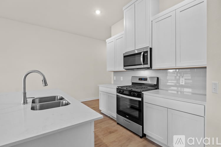 A kitchen with white cabinets and a stainless steel oven.