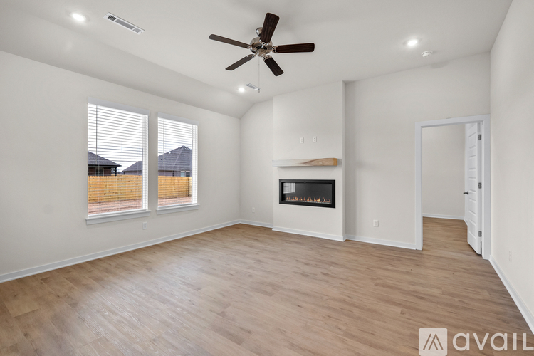 A spacious room with a ceiling fan and a fireplace.
