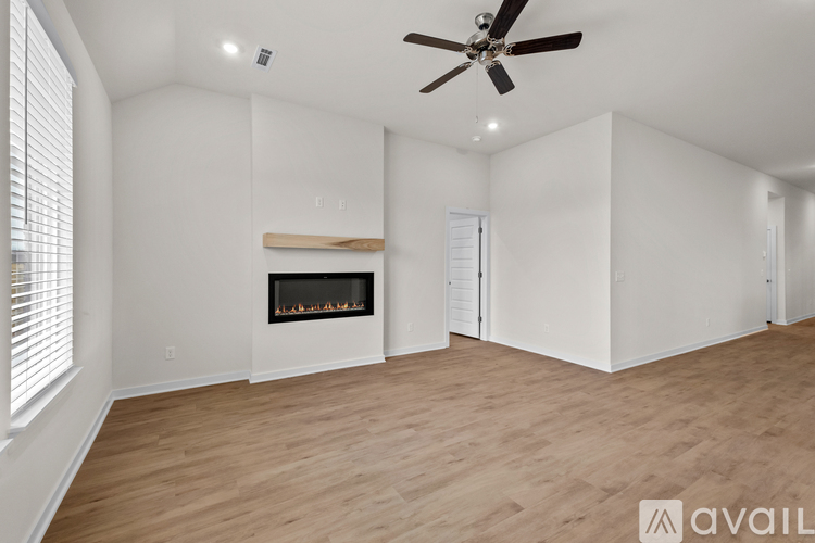 A spacious room with a fireplace and a ceiling fan.
