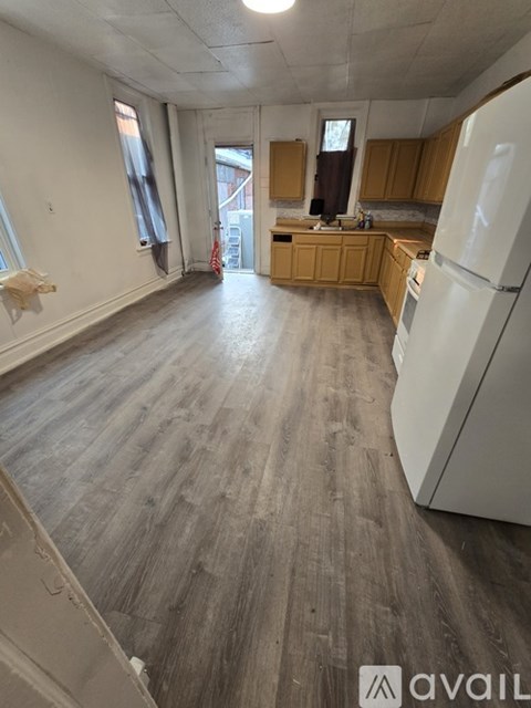 A kitchen with a white fridge and wooden cabinets.