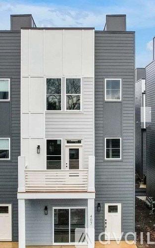 A modern two-story building with a balcony on the second floor.
