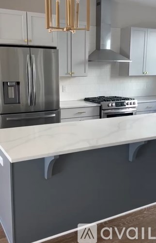 A kitchen with a stainless steel refrigerator and a white countertop.