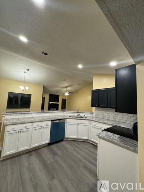 A kitchen with white cabinets and a blue dishwasher.