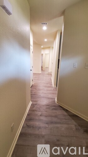 A long hallway with a carpeted floor and white walls.