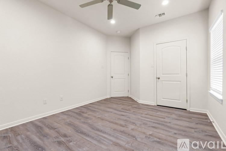 A room with a wooden floor and a white door.
