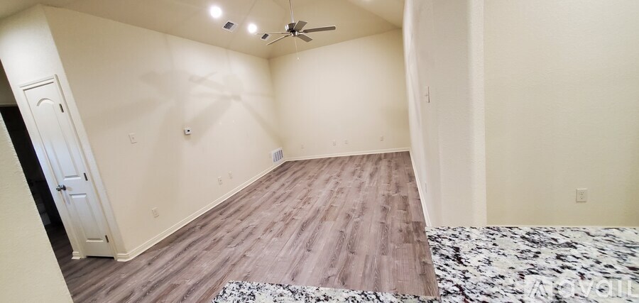 A room with a wooden floor and a ceiling fan.