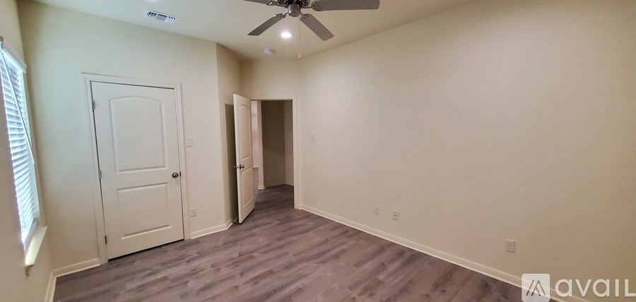 A room with a ceiling fan and two doors.