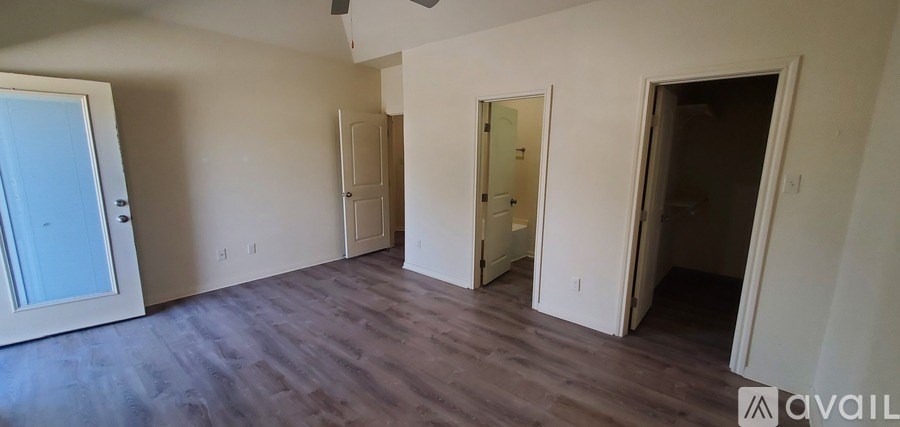 A large empty room with wooden floors and white walls.