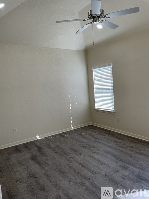 A room with a ceiling fan and a window with blinds.