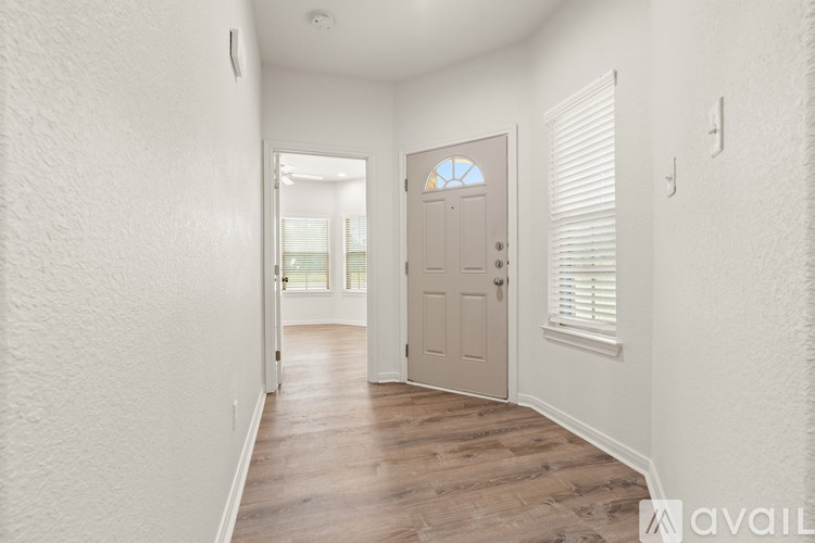 A white toilet is in a bathroom with a white tub and a white sink.