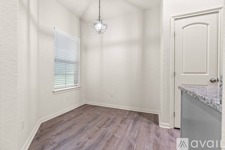 A room with a door and a window with blinds.
