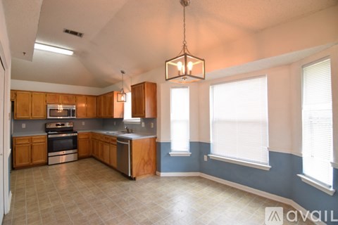 A kitchen with wooden cabinets and a tile floor.
