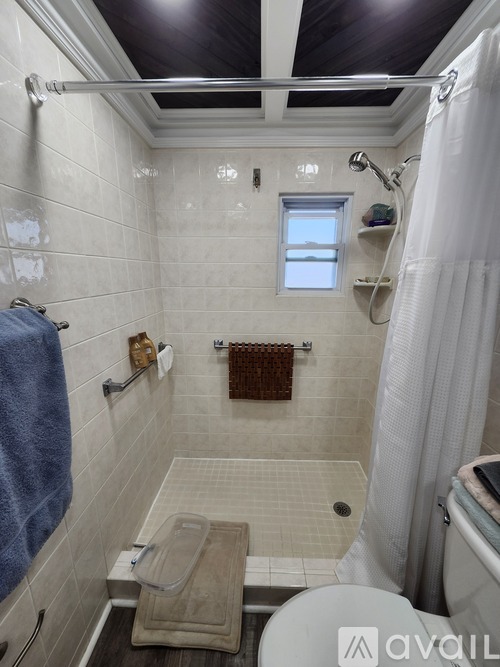 A bathroom with a towel hanging on the wall and a shower curtain.