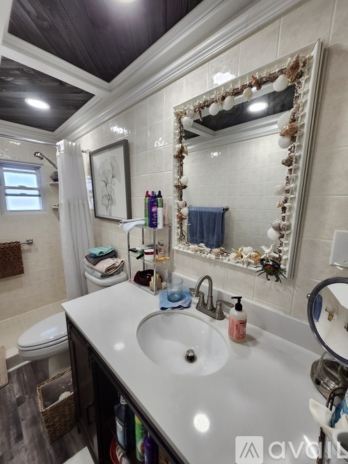 A bathroom with a white sink and a large mirror.