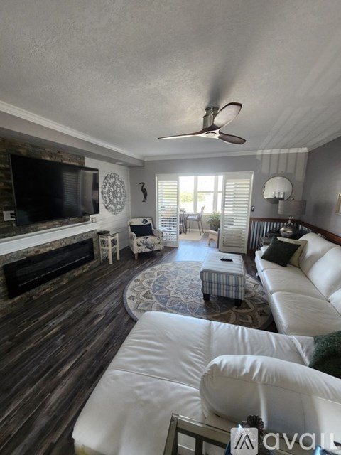 A living room with a white couch and a fireplace.