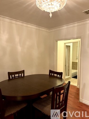 A dining room with a round table and chairs.