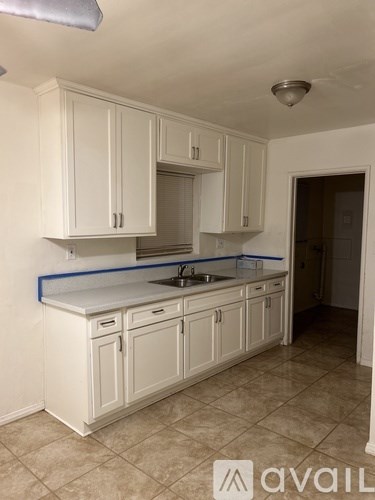 A kitchen with white cabinets and a countertop.
