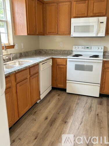 A kitchen with wooden cabinets and a white stove.