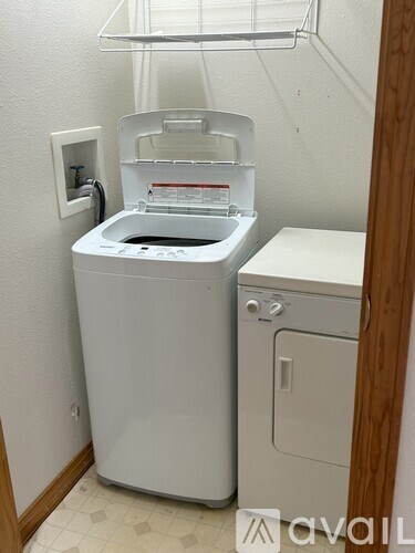 A white front loading washing machine in a small room.